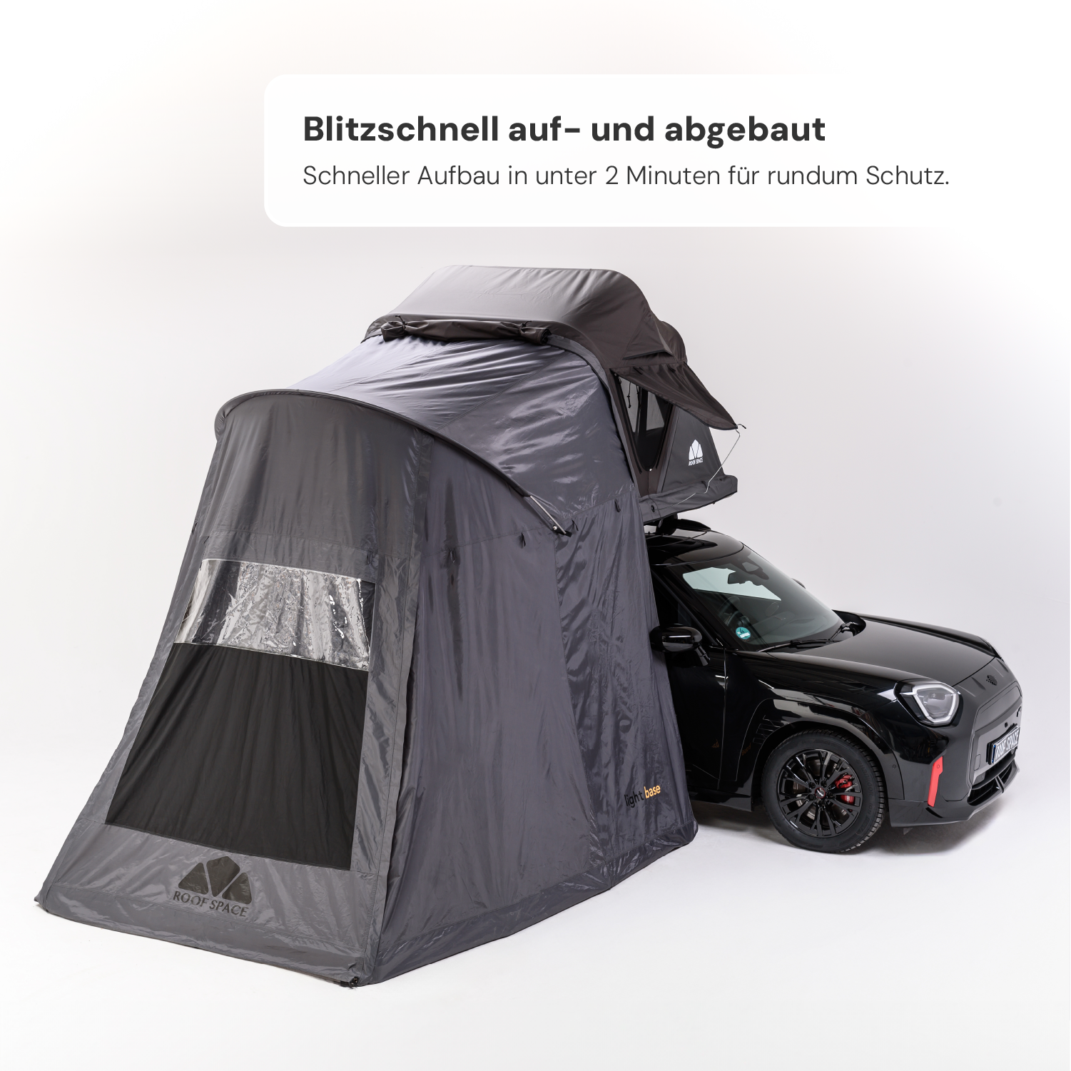 Ein schwarzes Auto mit einem grauen Zeltaufbau, Text oben: "Blitzschnell auf- und abgebaut. ROOF SPACE, light base"