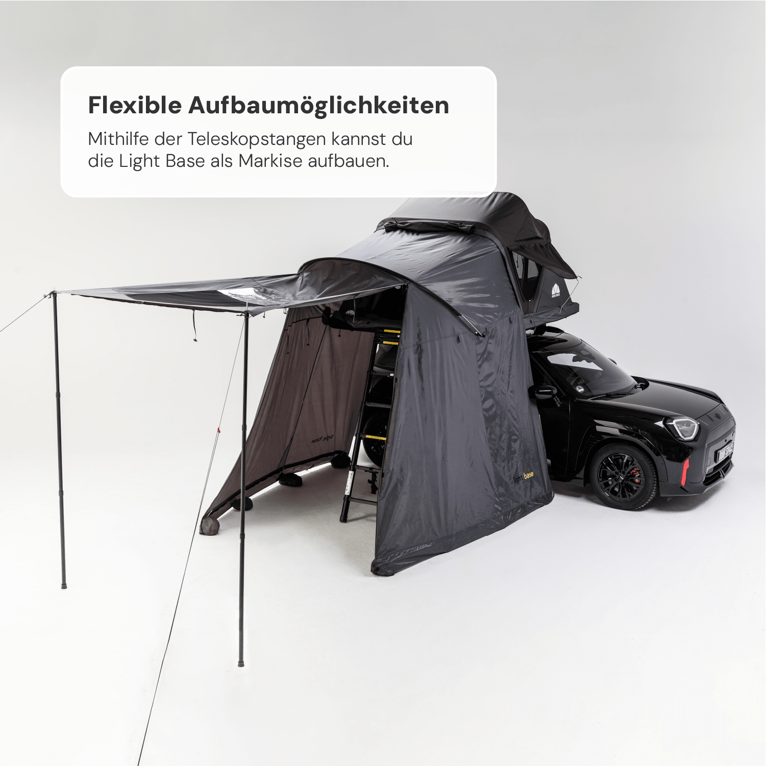 Ein schwarzes Auto mit einem auf dem Dach montierten, grauen Zelt mit Markise und Aufschrift „Light Base“ vor weißem Hintergrund. Text: „Flexible Aufbaumöglichkeiten“.