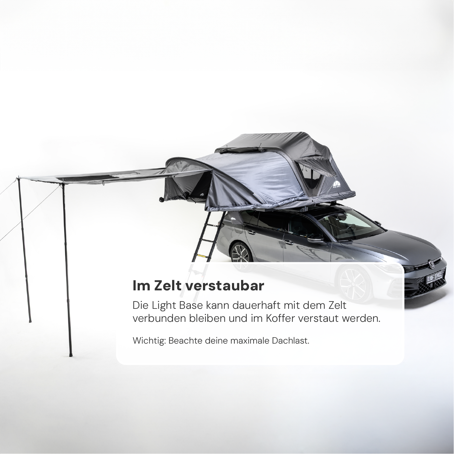 Ein graues Auto mit einem grauen Dachzelt und Markise vor einem weißen Hintergrund. Text: "Im Zelt verstaubar... Dachlast."