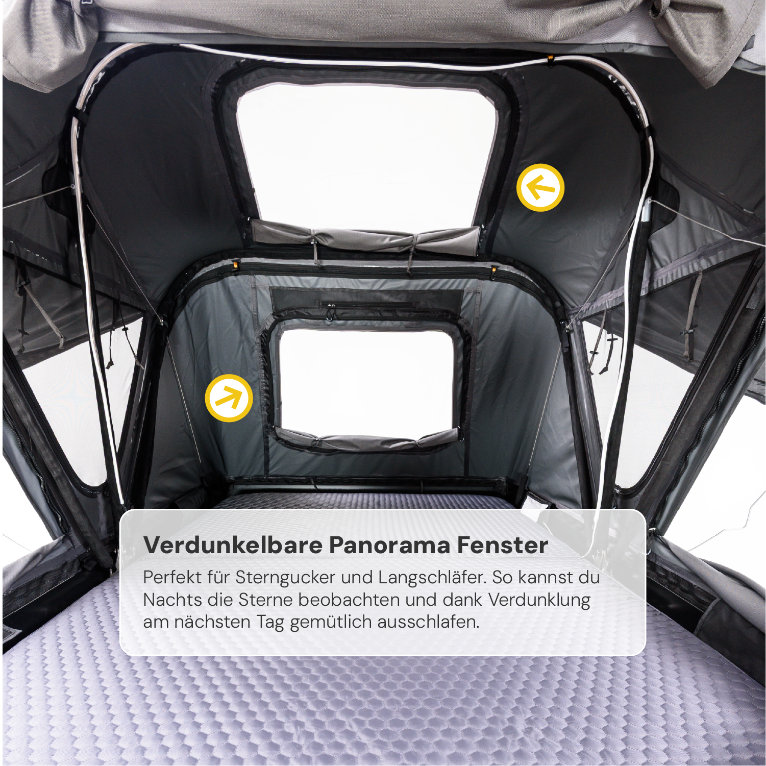 Innenansicht eines Dachzeltes mit Matratze, Panoramafenstern und Verdunkelung. Text: "Verdunkelbare Panorama Fenster. Perfekt für Sterngucker...". Gelbe Pfeile weisen auf Details.