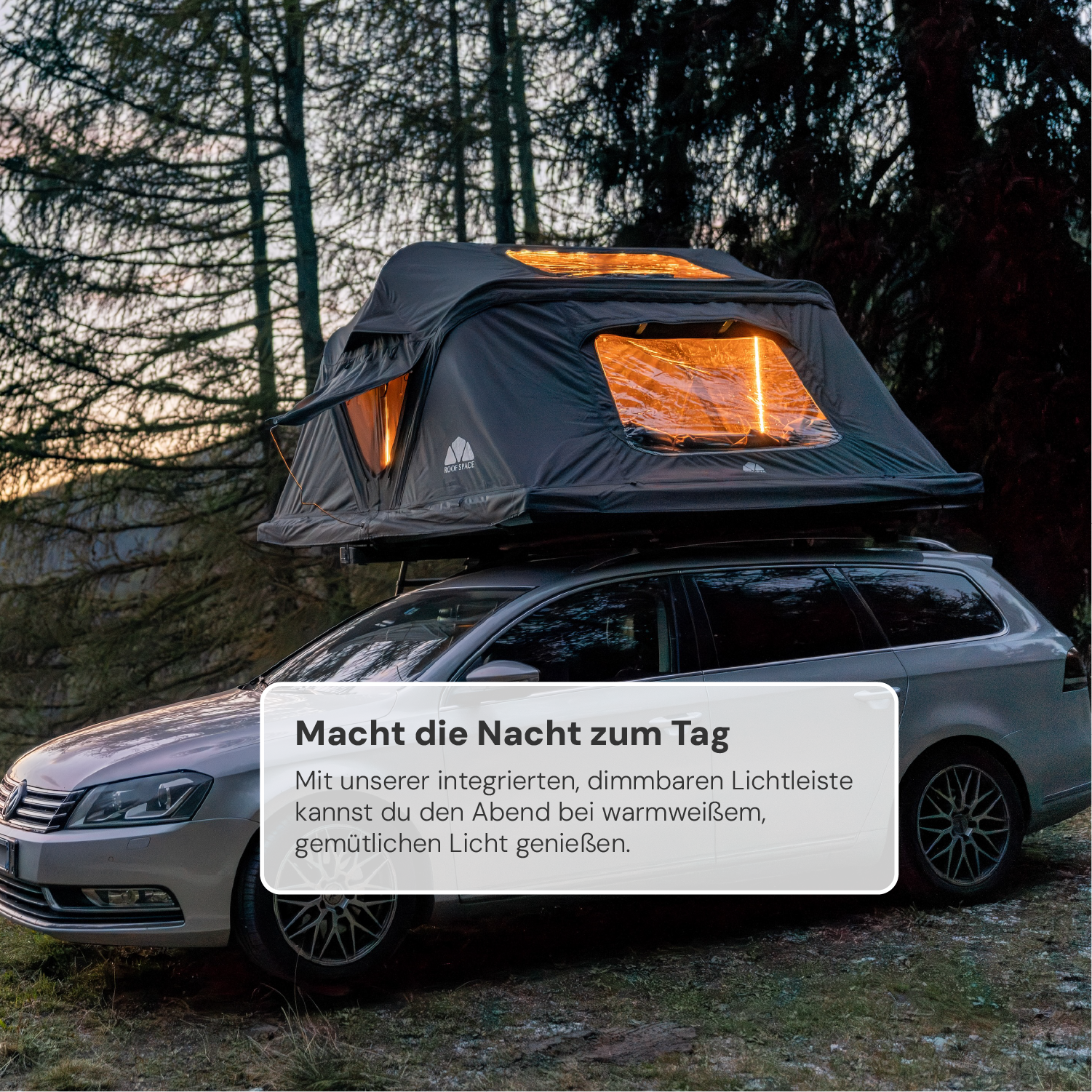 Ein grauer Kombi mit einem beleuchteten Dachzelt steht vor einem dunklen Wald. Das Textfeld "Macht die Nacht zum Tag" ist sichtbar.