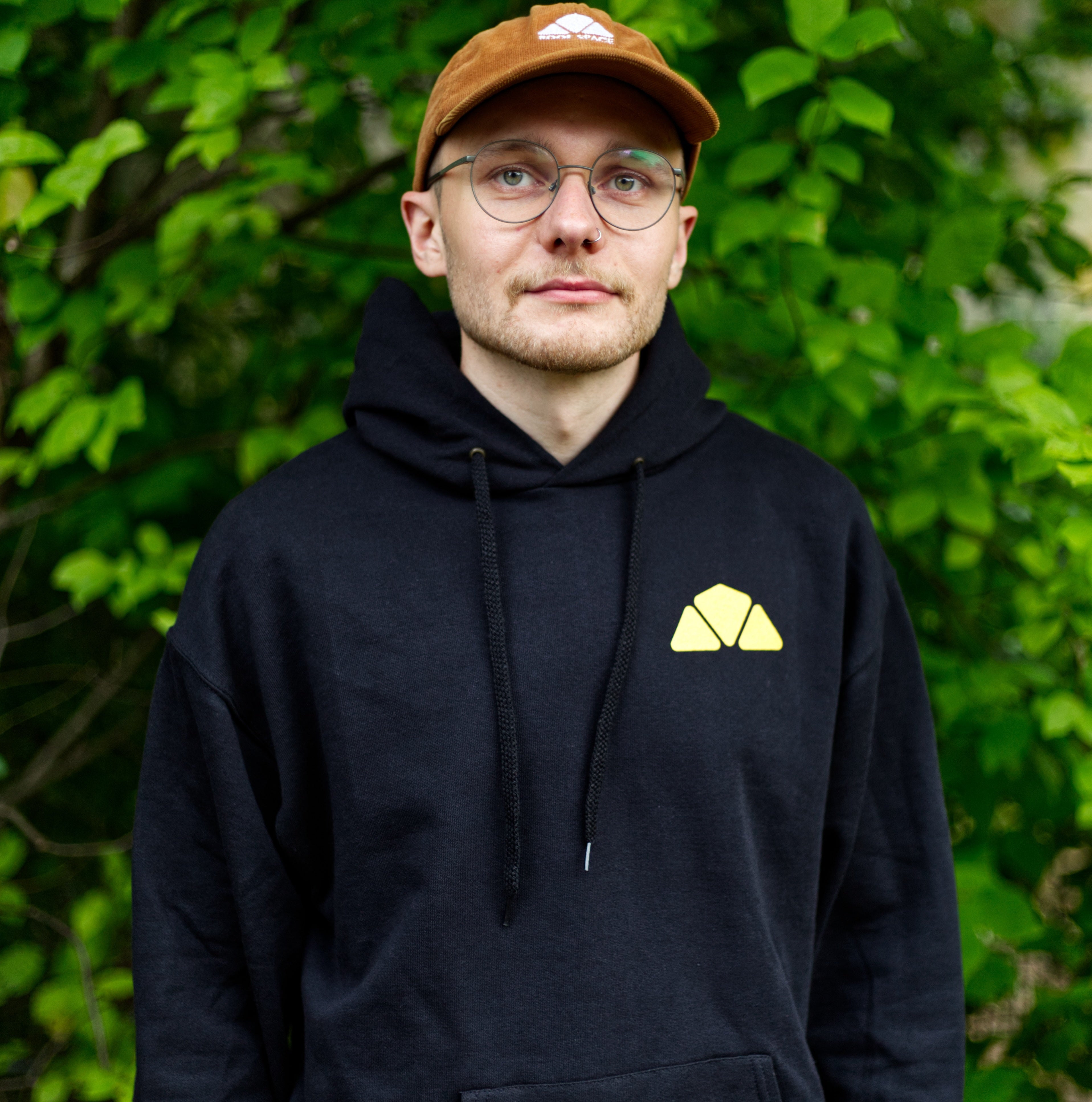 Schwarzer Hoodie mit gelbem geometrischem Logo auf der linken Brust