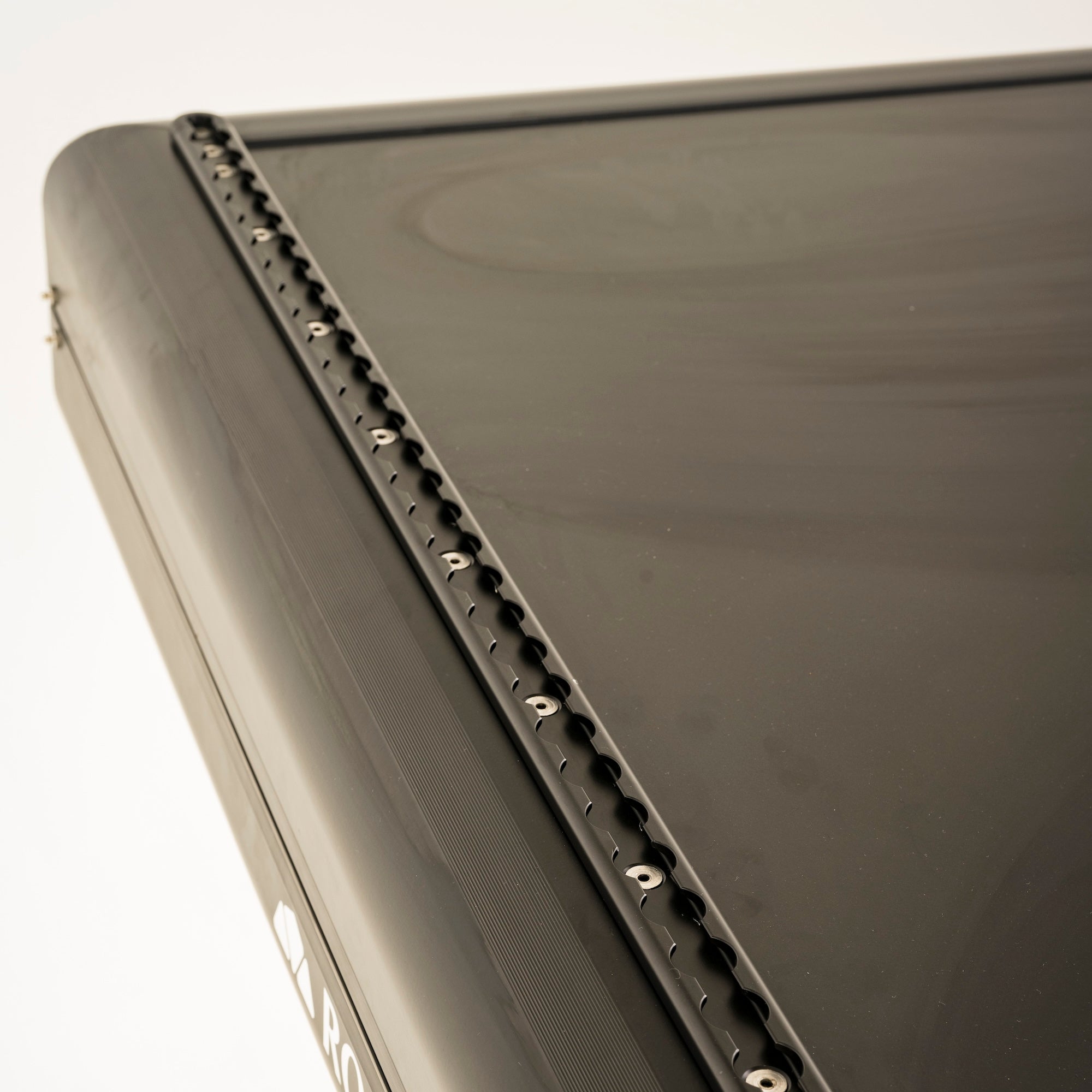 Schwarzer Metall-L-Track-Dachgepäckträger mit texturierter Oberfläche und kreisförmigen Befestigungen