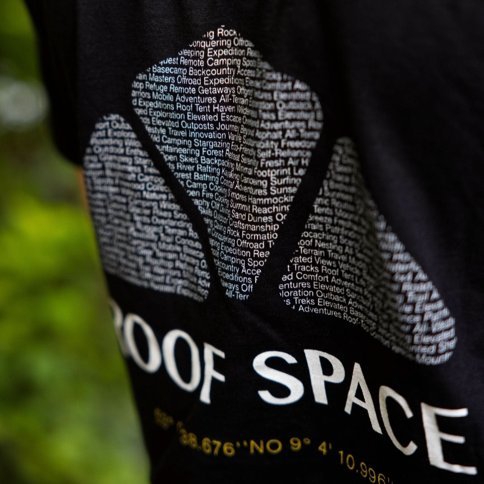 Schwarzes T-Shirt mit weißem Roof Space Design und gelben Koordinaten