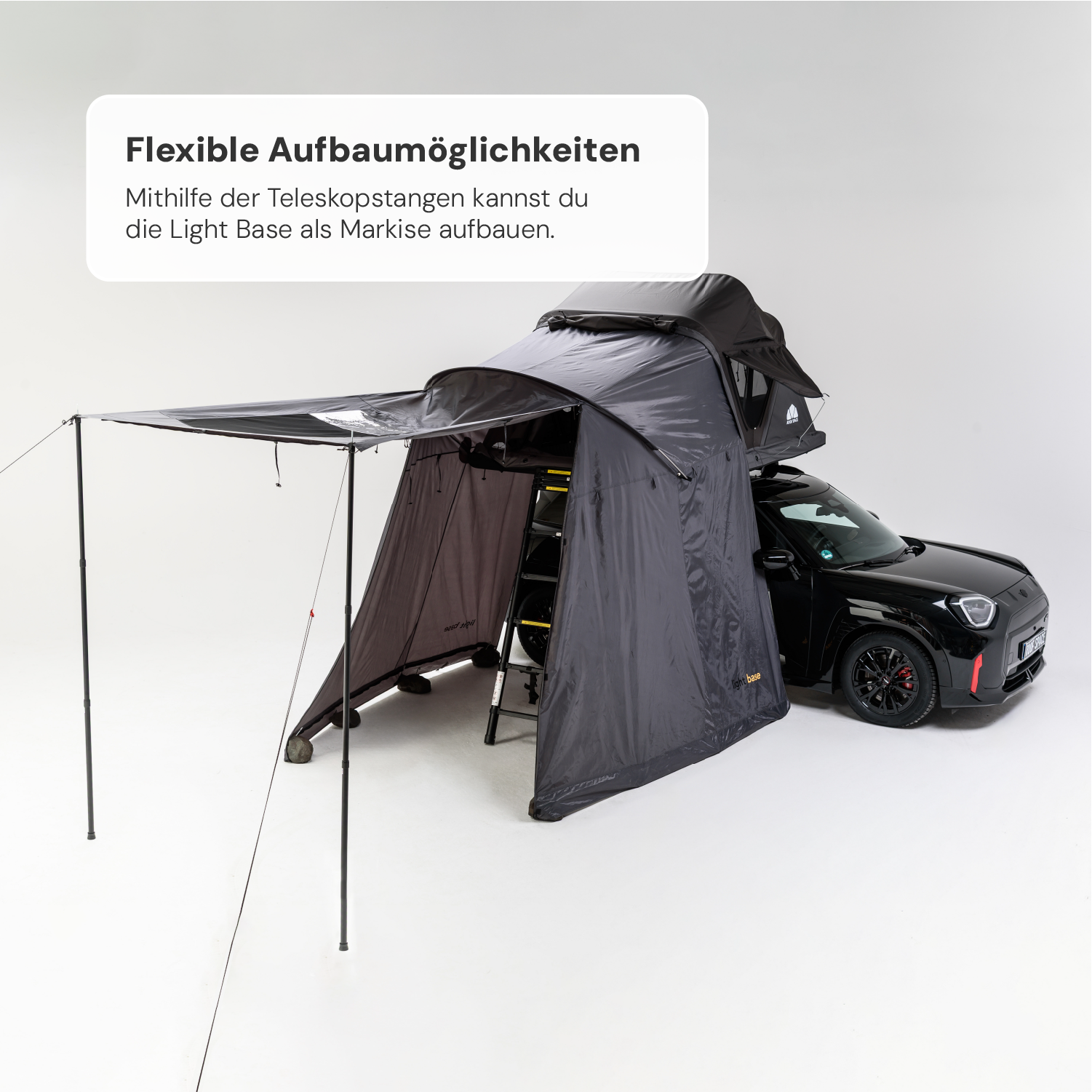Ein schwarzes Auto mit einem auf dem Dach montierten, grauen Zelt mit Markise und Aufschrift „Light Base“ vor weißem Hintergrund. Text: „Flexible Aufbaumöglichkeiten“.