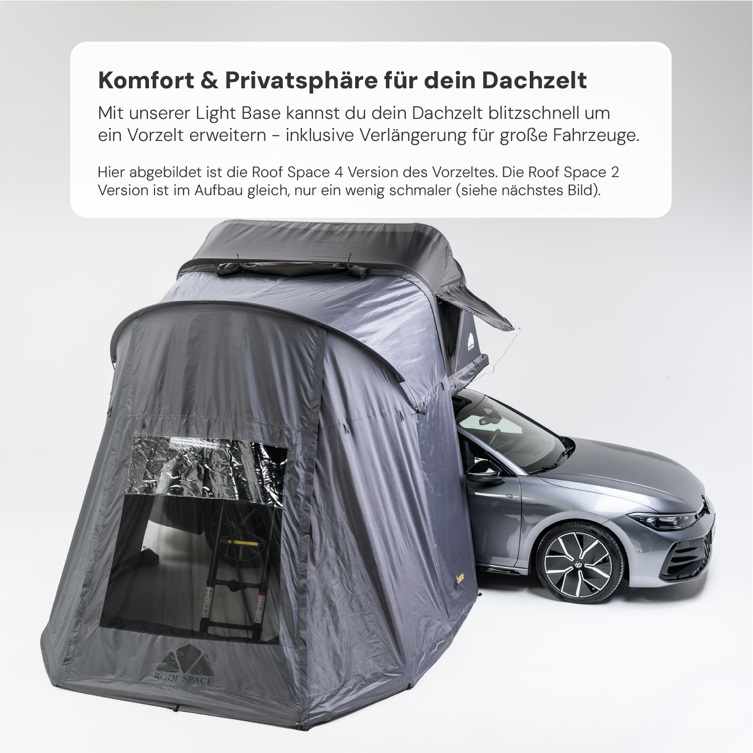 Ein graues Dachzeltvorzelt "Roof Space" ist an ein silbernes Auto angebracht, das im Hintergrund vor einem weißen Hintergrund steht. Der Text darüber wirbt für "Komfort & Privatsphäre für dein Dachzelt".