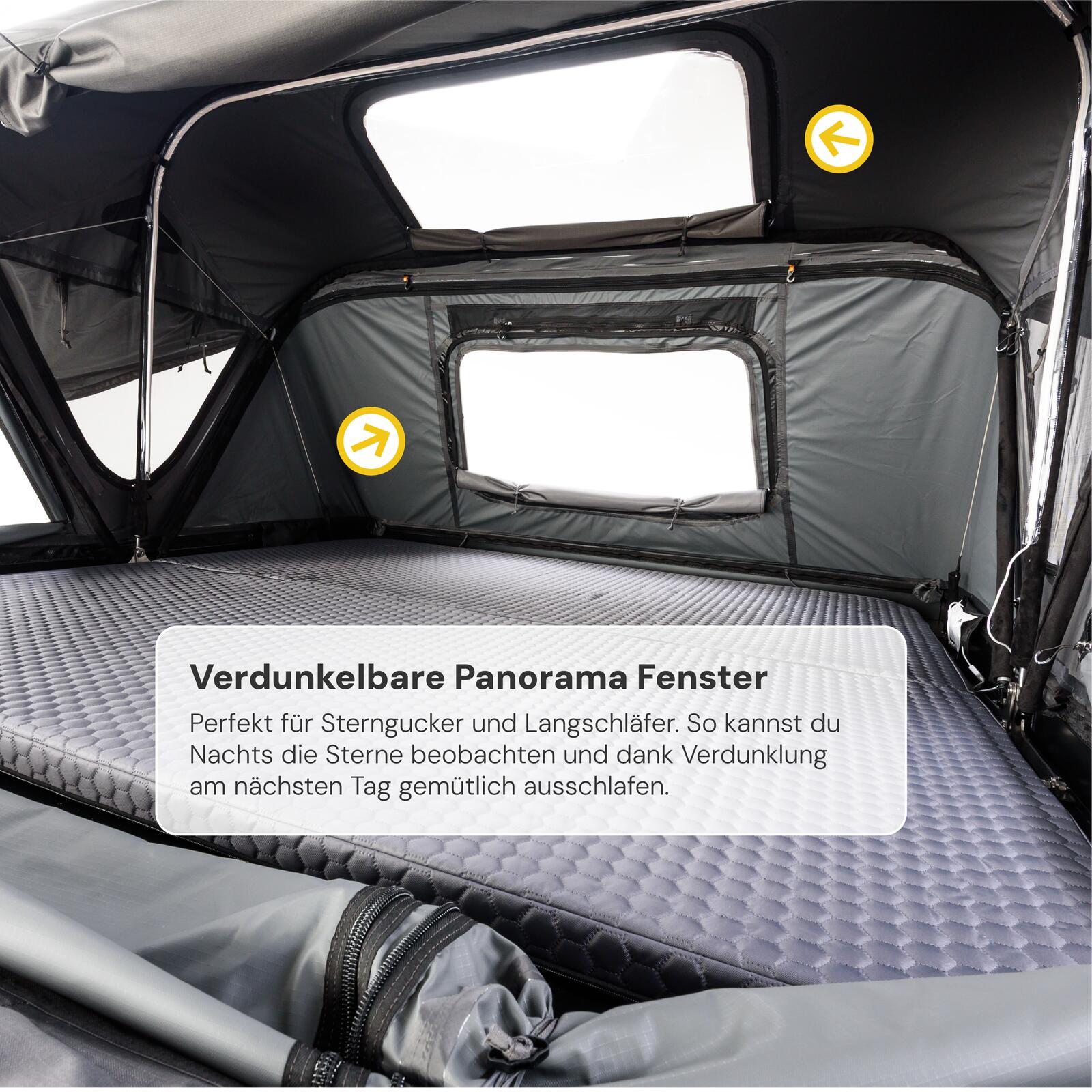 Innenansicht eines Dachzeltes mit grauer Matratze, Panoramafenstern und Verdunkelung, Text: "Verdunkelbare Panorama Fenster".
