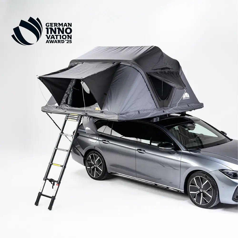 Grey car with a rooftop tent and ladder against a light background. Text at the top left: "WINNER OF THE GERMAN INNOVATION AWARD '25".