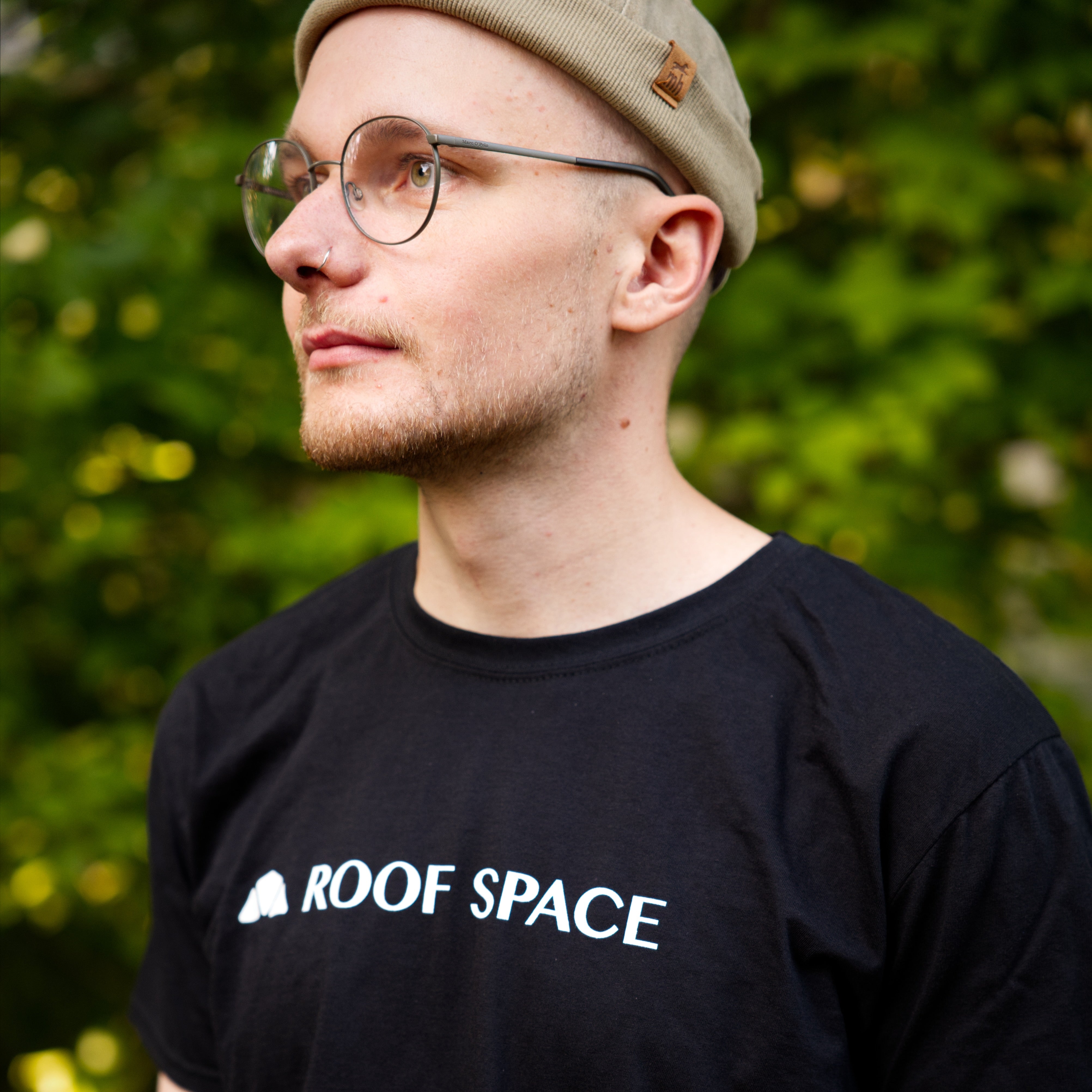 Schwarzes T-Shirt mit weißem Roof Space-Text und Bergsymbol