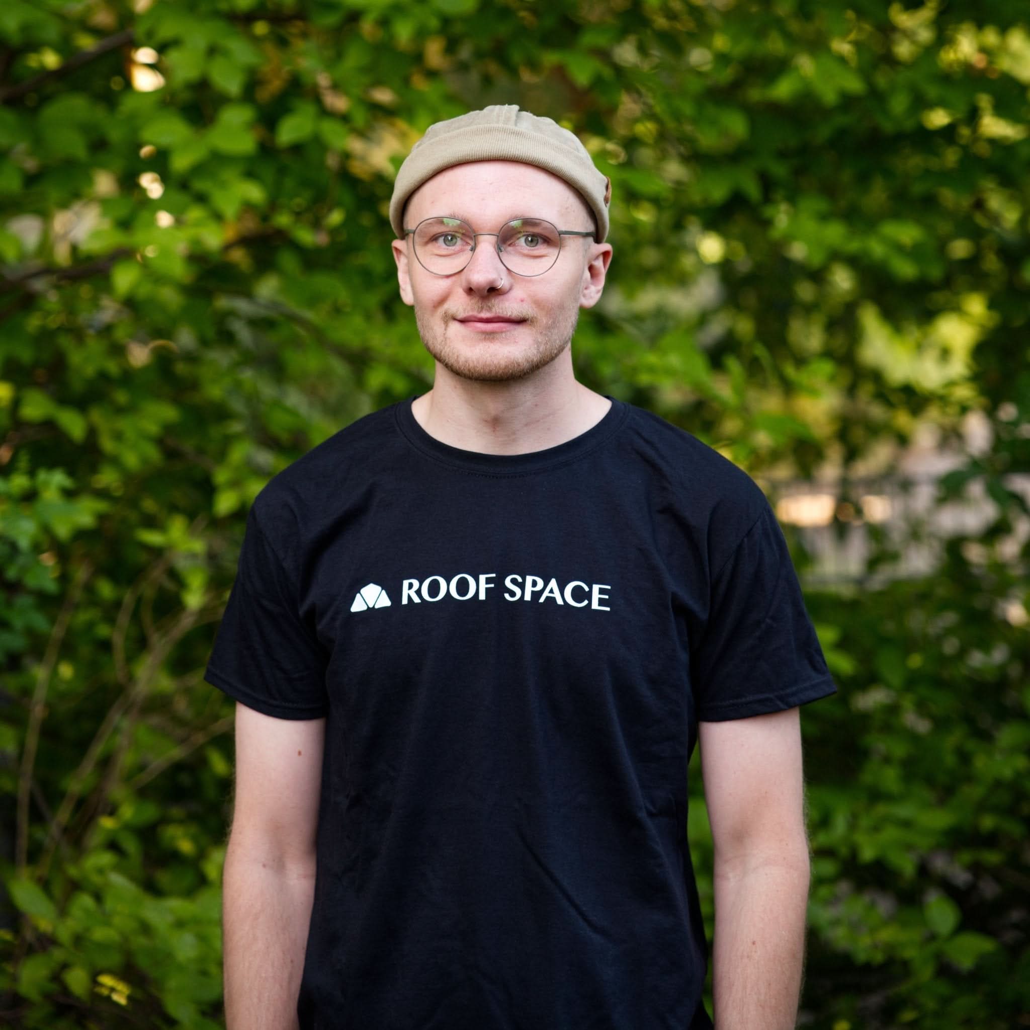 Schwarzes Baumwoll-T-Shirt mit weißem Roof Space Logo und Dreieck-Emblem